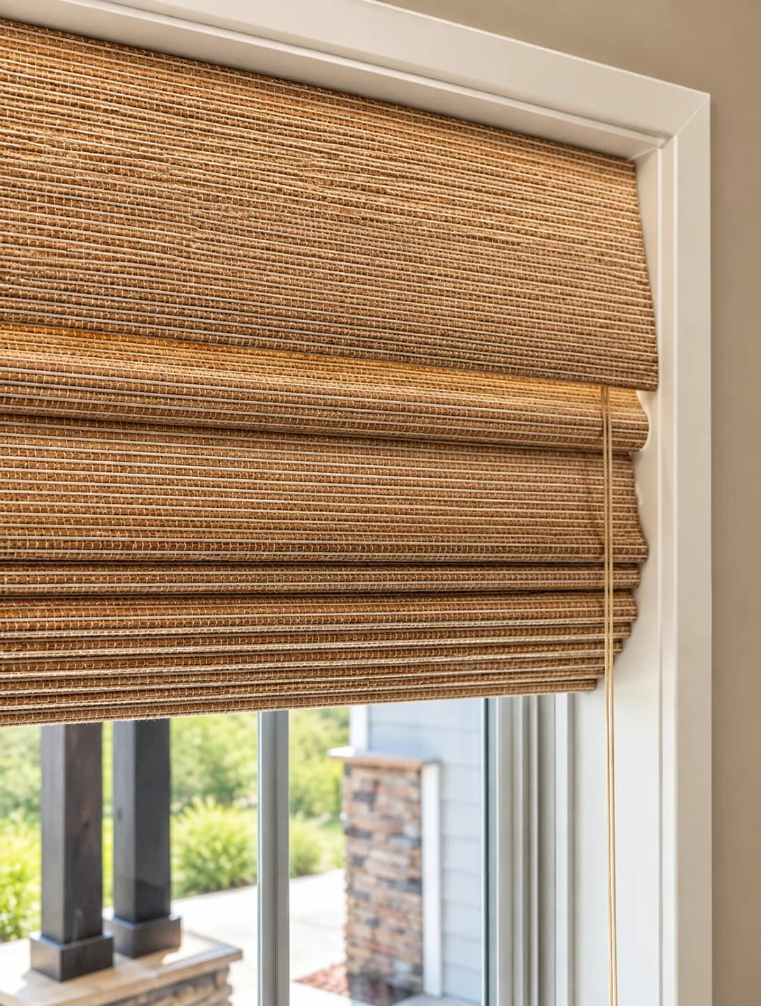 Tailored woven Roman shade in a warm natural texture